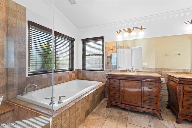 bathroom featuring tile patterned floors, vanity, tiled tub, tile walls, and lofted ceiling