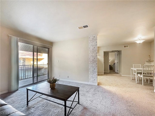 carpeted living room with decorative columns