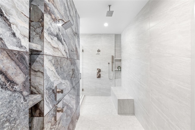 bathroom with tiled shower and tile walls