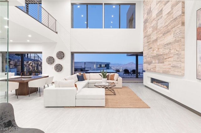 living room with a towering ceiling and a fireplace