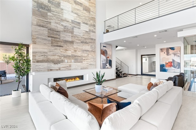 living room with a towering ceiling and a fireplace