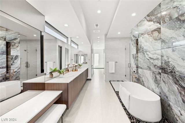 bathroom featuring tile patterned flooring, vanity, separate shower and tub, and tile walls