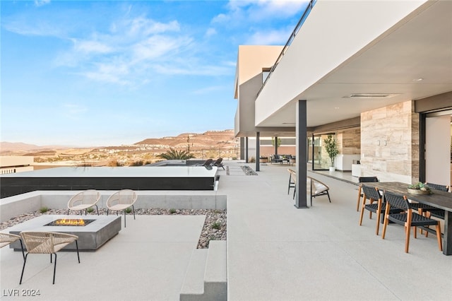 view of patio featuring a fire pit and a mountain view