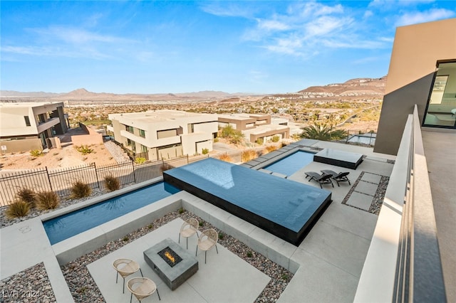 view of pool with a mountain view, a patio, and a fire pit