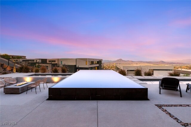 patio terrace at dusk with a mountain view and an outdoor fire pit