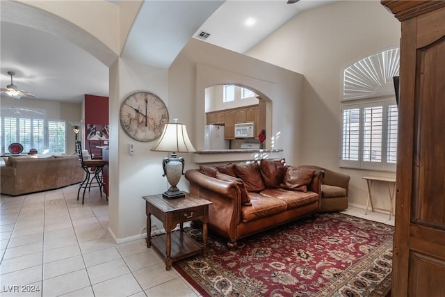 living room with light tile patterned floors, ceiling fan, and lofted ceiling