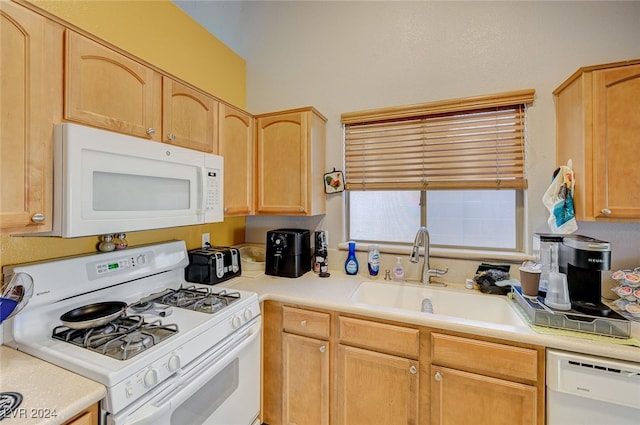 kitchen featuring light brown cabinetry, sink, and white appliances