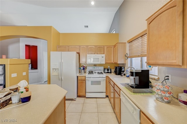 kitchen with light brown cabinets, white appliances, sink, vaulted ceiling, and light tile patterned floors