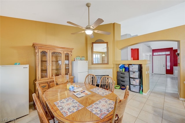 dining room featuring light tile patterned floors, a towering ceiling, and ceiling fan