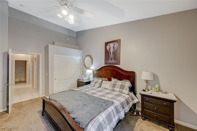 carpeted bedroom with ceiling fan and a closet