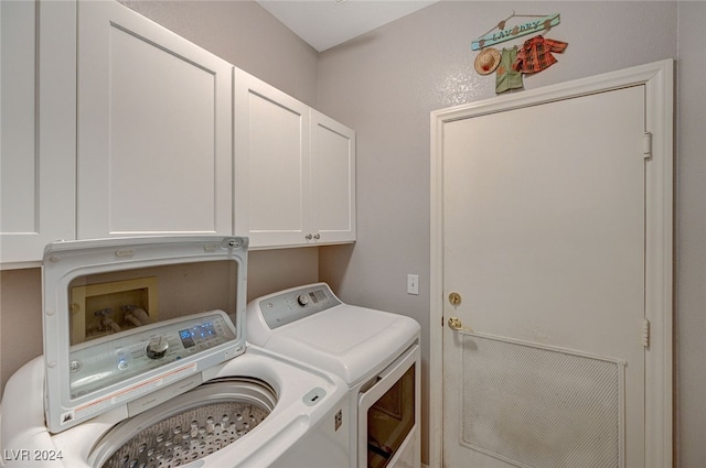 laundry area featuring washer and dryer and cabinets