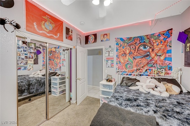 carpeted bedroom with ceiling fan and a closet