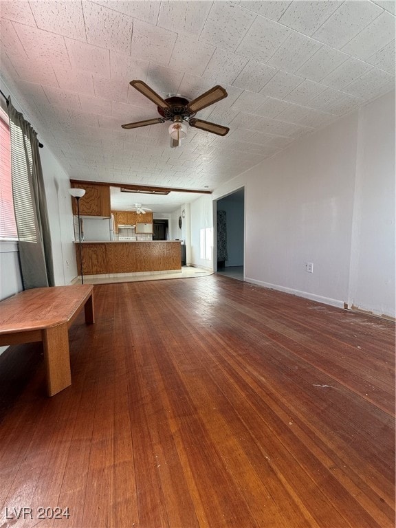 unfurnished living room with ceiling fan and hardwood / wood-style flooring