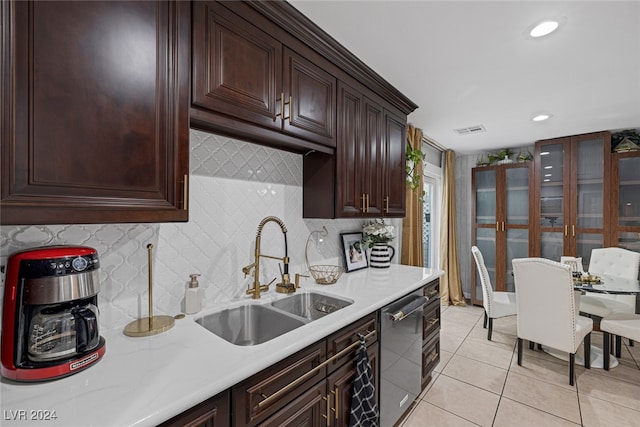 kitchen featuring decorative backsplash, dishwasher, light tile patterned flooring, and sink