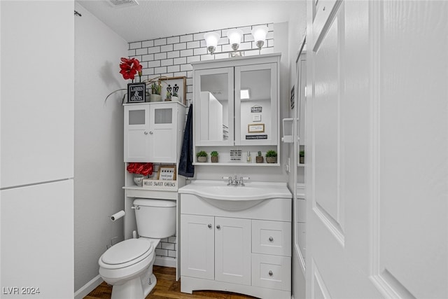 bathroom featuring hardwood / wood-style floors, vanity, a textured ceiling, and toilet