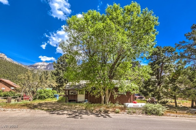 view of property hidden behind natural elements featuring a mountain view