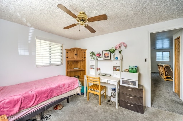 carpeted bedroom featuring ceiling fan and a textured ceiling