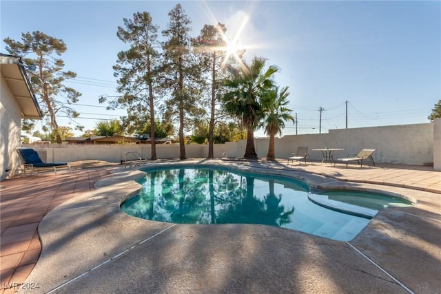 view of swimming pool featuring an in ground hot tub and a patio area