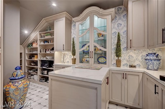 kitchen featuring kitchen peninsula and light stone counters