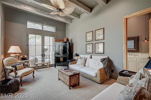 living room featuring light carpet, french doors, sink, ceiling fan, and beamed ceiling