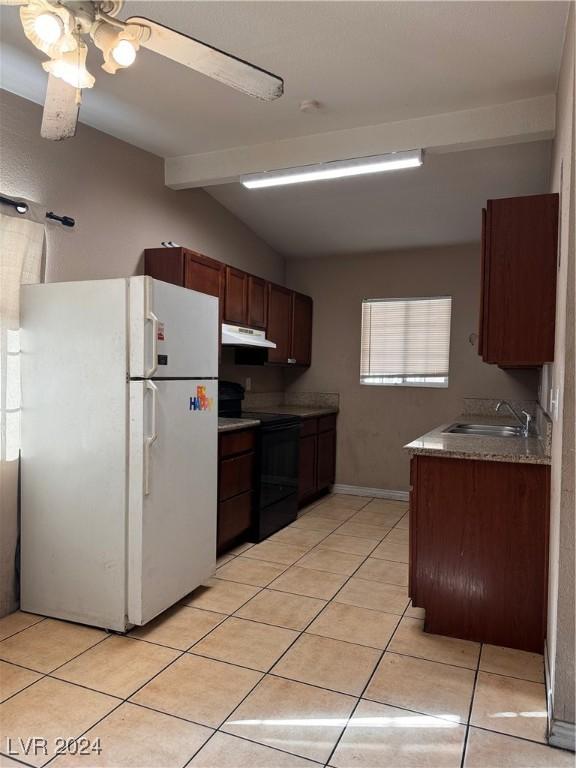 kitchen featuring sink, light tile patterned floors, white fridge, ceiling fan, and black range with electric stovetop