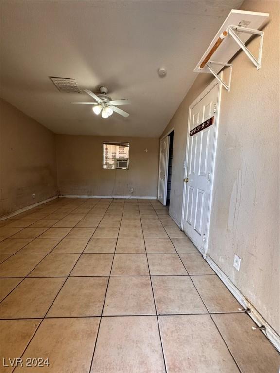 tiled spare room with cooling unit and ceiling fan