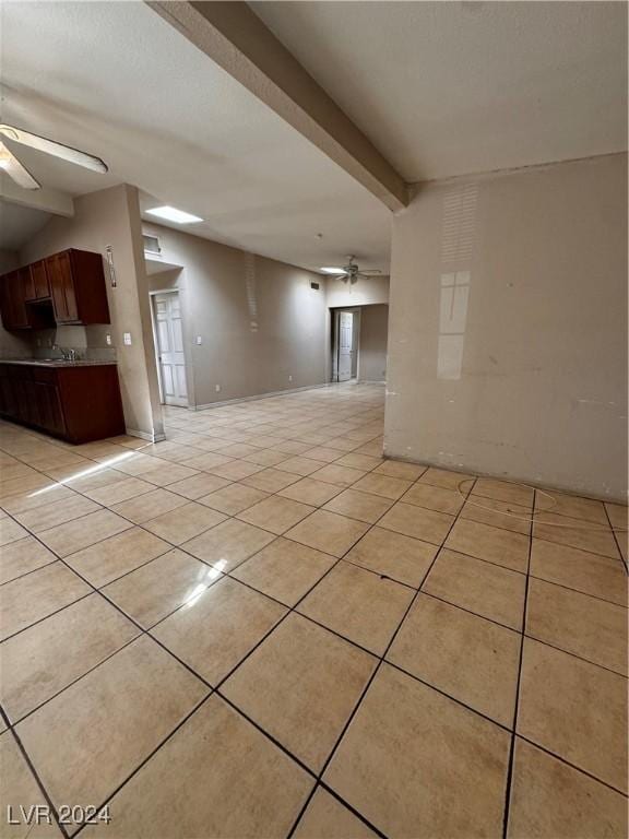 spare room with beamed ceiling, ceiling fan, and light tile patterned flooring