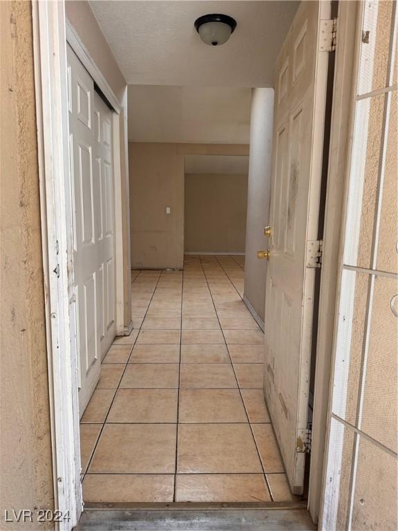 hall featuring light tile patterned flooring