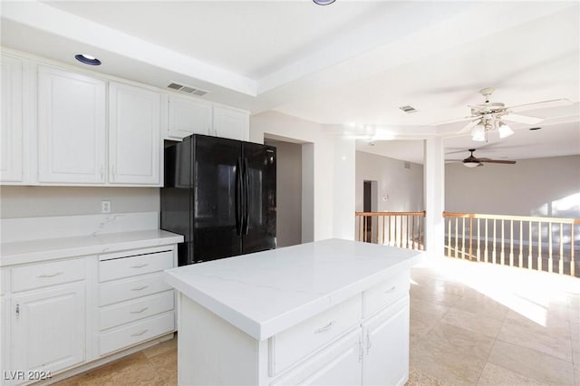 kitchen featuring black fridge, white cabinetry, ceiling fan, and a kitchen island