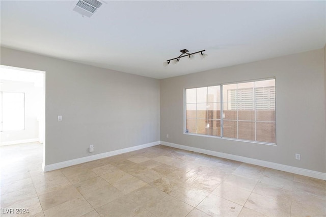 unfurnished room featuring rail lighting