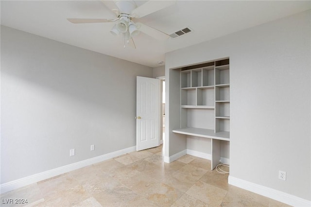 unfurnished bedroom with built in desk and ceiling fan