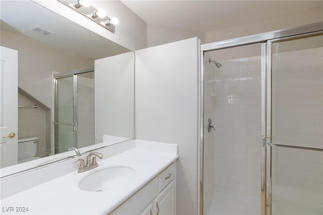 bathroom with vanity, toilet, and an enclosed shower