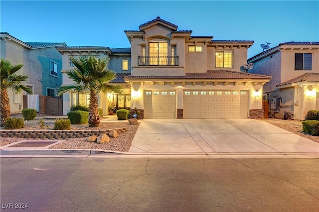 mediterranean / spanish house featuring a garage and a balcony