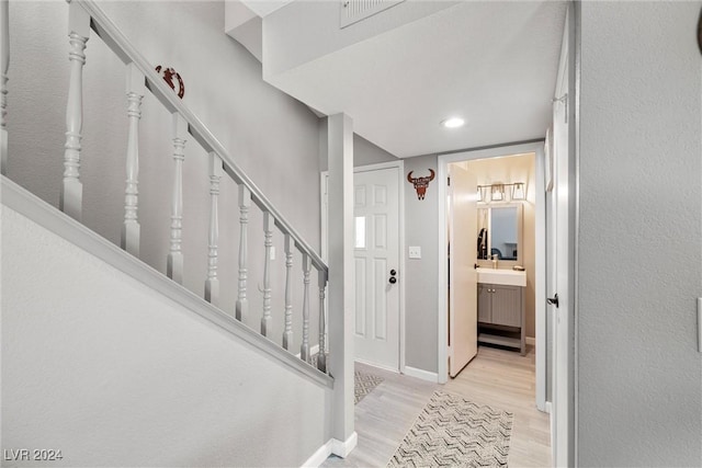 staircase featuring wood finished floors, visible vents, and baseboards