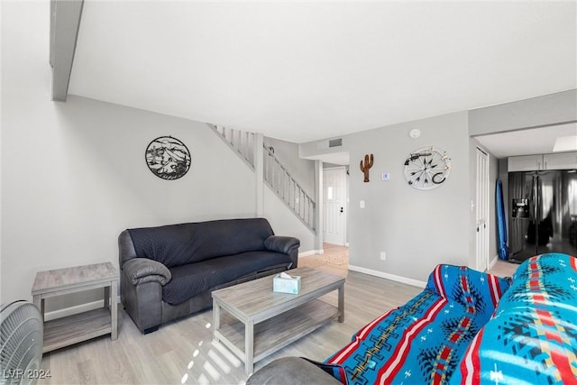 living room with stairway, baseboards, and wood finished floors