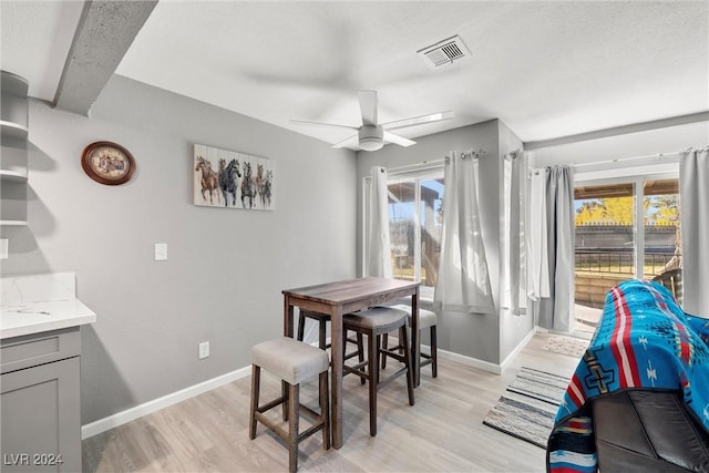 dining room with light wood-type flooring, plenty of natural light, and visible vents