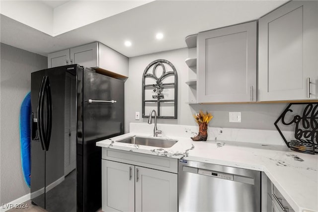 kitchen featuring black fridge with ice dispenser, gray cabinetry, stainless steel dishwasher, open shelves, and a sink