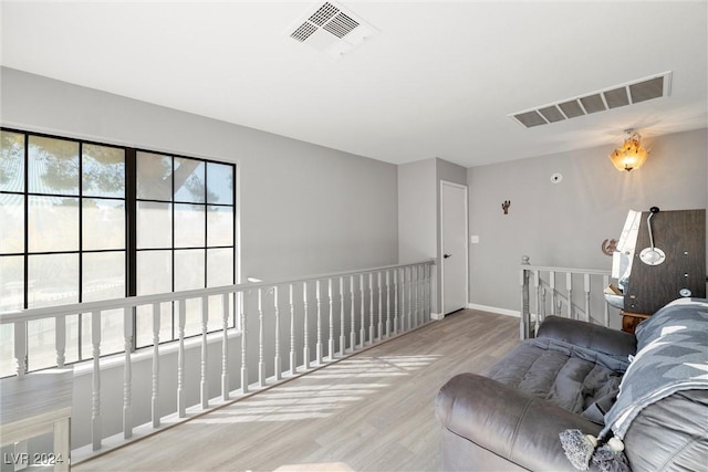 living area featuring baseboards, visible vents, and wood finished floors