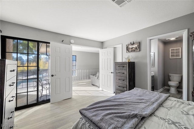 bedroom featuring access to exterior, visible vents, light wood-style flooring, and ensuite bath