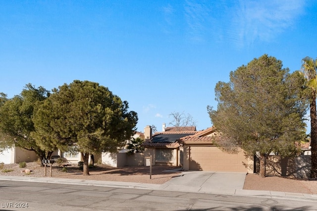 view of front facade with a garage and solar panels