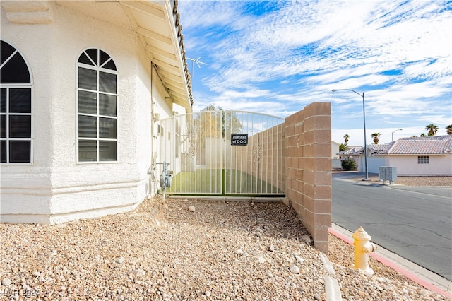 view of property exterior featuring a gate and stucco siding