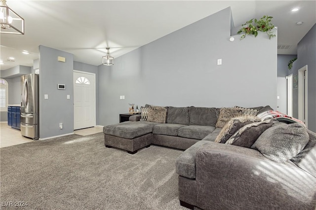 living area with light carpet, vaulted ceiling, visible vents, and baseboards