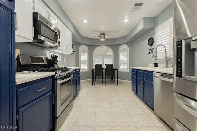 kitchen with appliances with stainless steel finishes, light countertops, blue cabinets, and visible vents