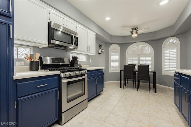 kitchen with light countertops, appliances with stainless steel finishes, white cabinets, and blue cabinets