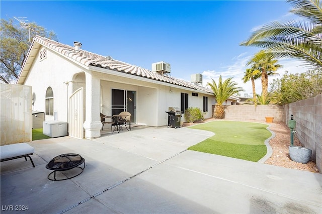 rear view of property featuring a patio, central AC unit, a fenced backyard, a tiled roof, and stucco siding