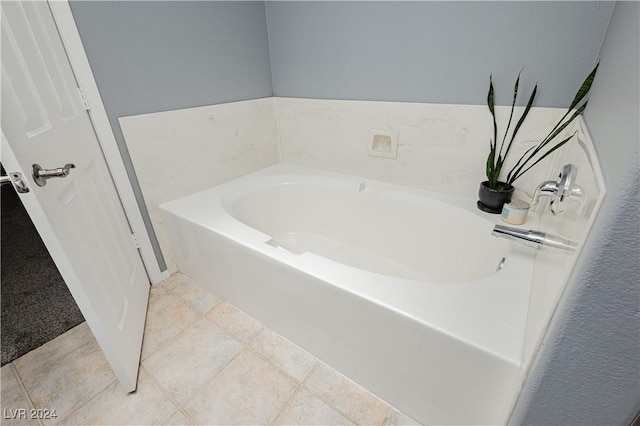 bathroom with a garden tub and tile patterned floors