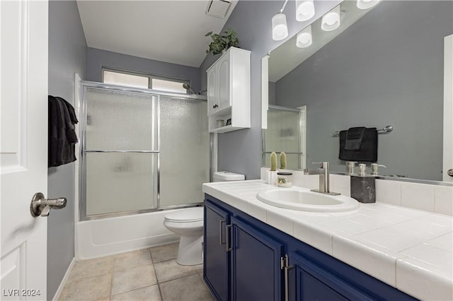 full bathroom with visible vents, toilet, combined bath / shower with glass door, vanity, and tile patterned flooring