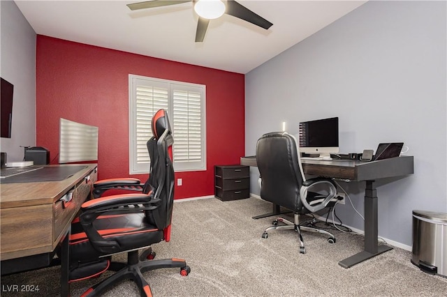 carpeted office space with ceiling fan and baseboards