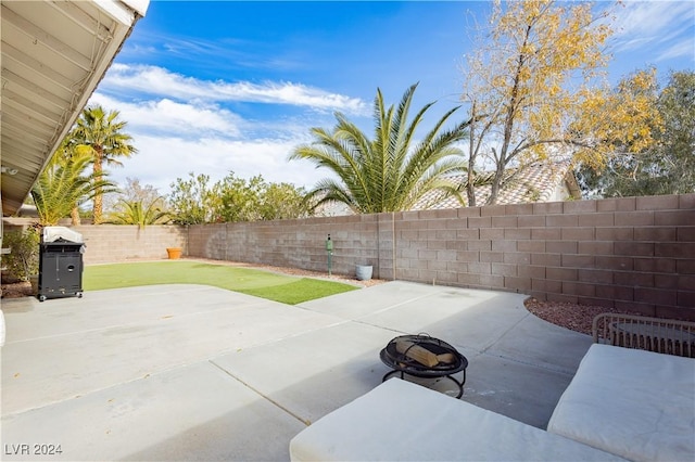 view of patio / terrace with a fenced backyard, a fire pit, and grilling area