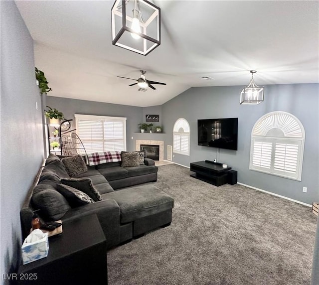 carpeted living area featuring lofted ceiling, ceiling fan, a fireplace, and baseboards